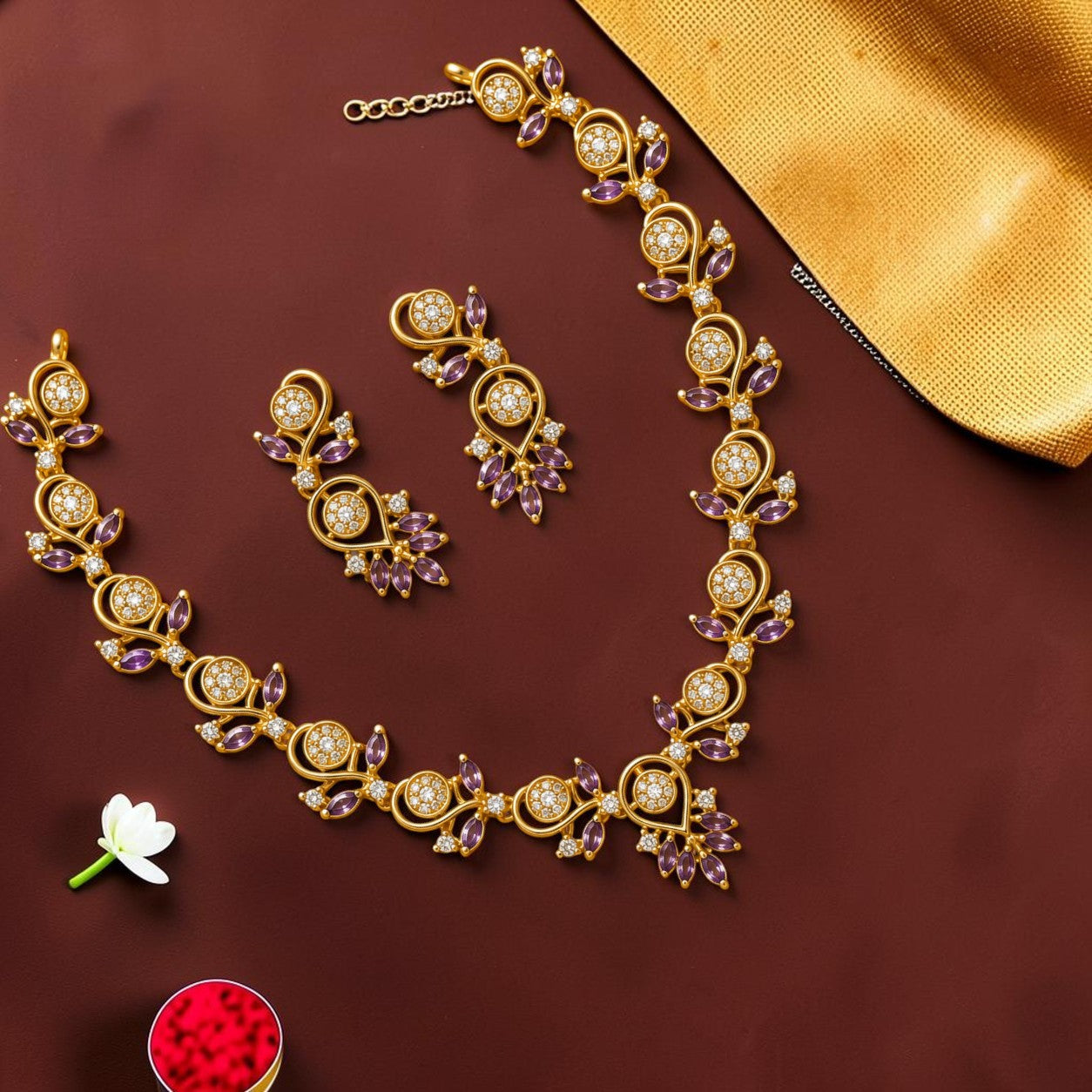 My Store gold-toned floral necklace and earring set with clear stones and purple accents on a dark background.