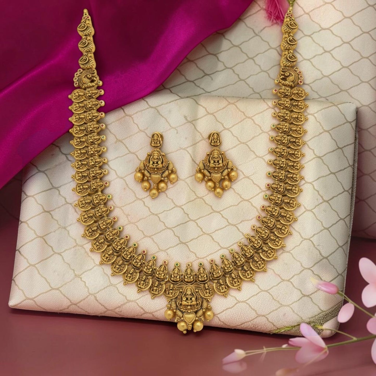 My Store antique gold-toned temple jewelry necklace and earring set with intricate deity motifs on a silk fabric.