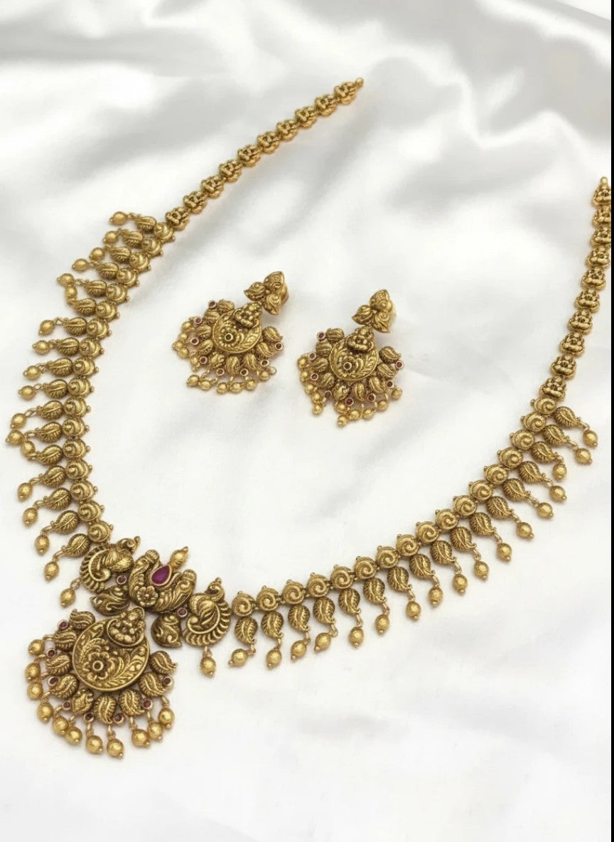 My Store antique gold-toned necklace and earring set with temple motifs, ruby stones, and hanging beads on white silk.