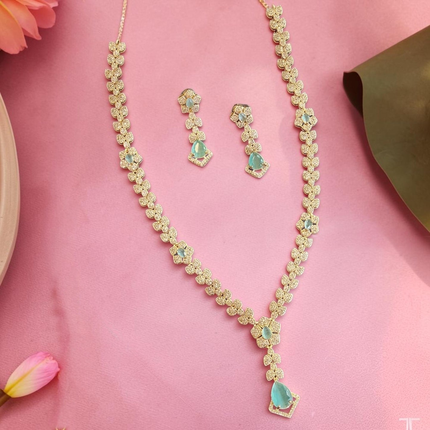 My Store Duchess Leaf Necklace Set with gold-tone floral motifs, cubic zirconia, and teal teardrop stones on pink