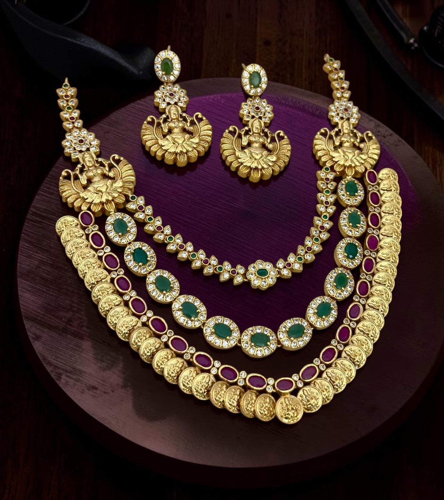 My Store multi-layered gold temple necklace set with ruby and green stones, deity motifs, and matching jhumka earrings.