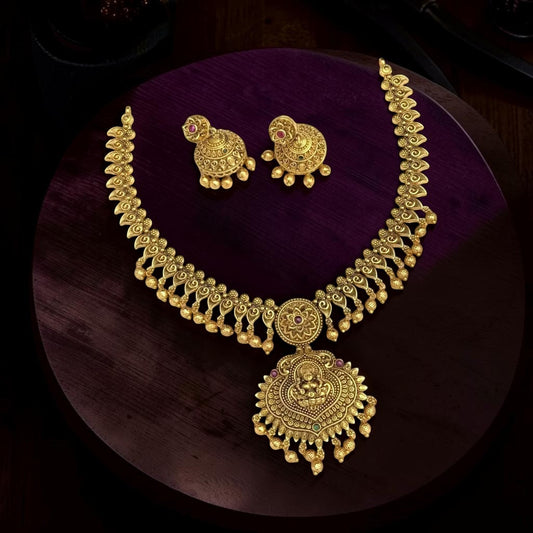My Store gold-toned temple jewelry necklace and jhumka earring set with intricate deity motifs and colorful stones.