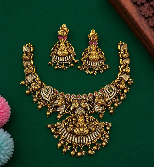 My Store traditional temple jewelry necklace and earring set in matte gold with deity motifs, red and green stone inlays.
